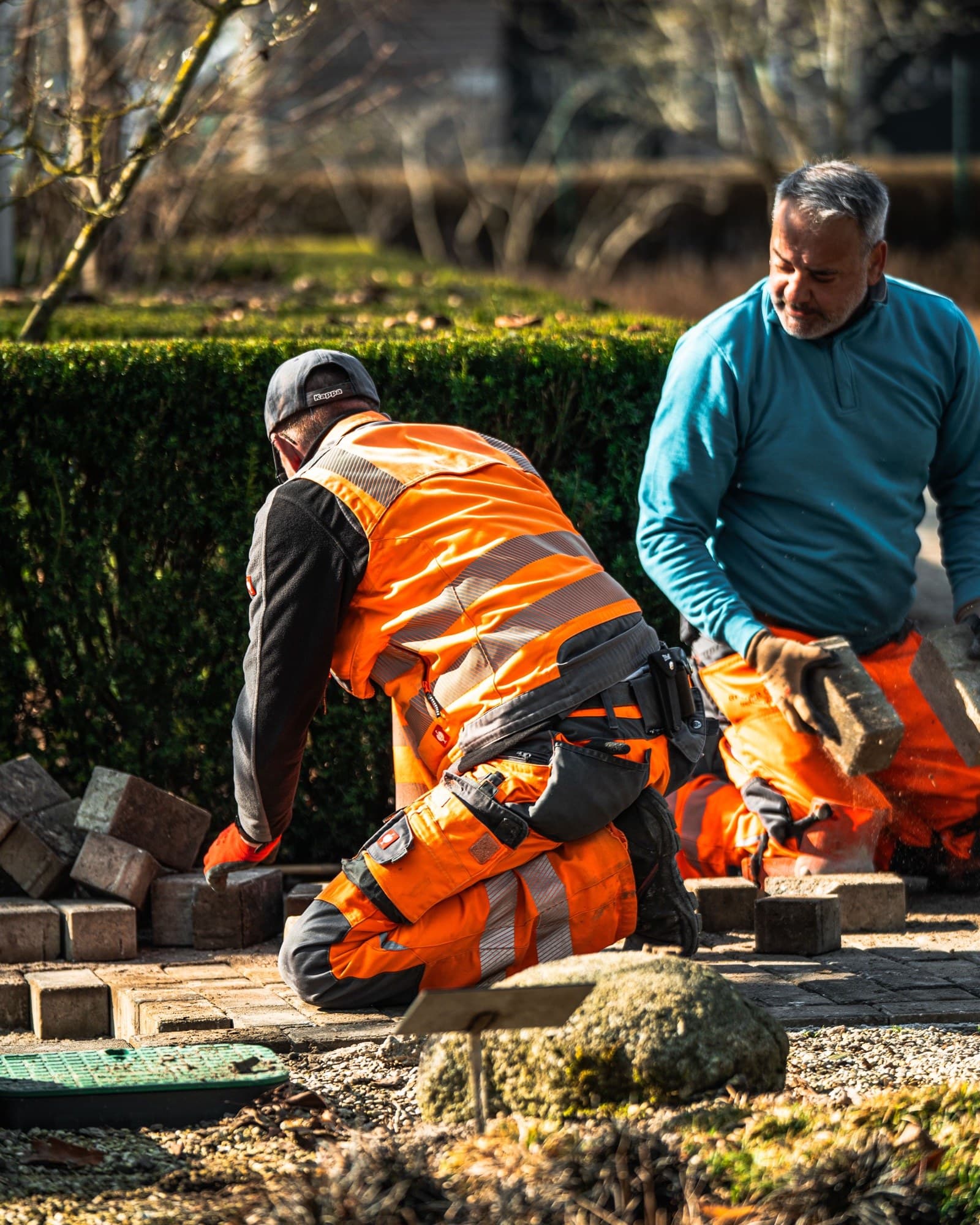 Zwei Mitarbeiter der Günter Cordes GmbH bei Pflasterarbeiten im Garten- und Landschaftsbau